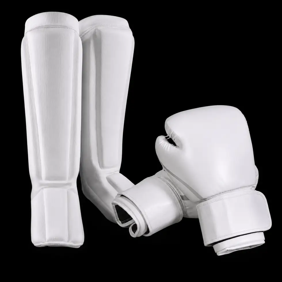 White kickboxing gloves and protective gear on a clean background